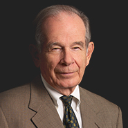 James J. Demma is wearing a brown suite, a white shirt, and a brown and green checked tie. Close up on face.