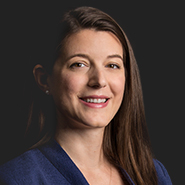Emily A. Higgs is smiling, wearing a blue jacket, and a white shirt. Close up on face.