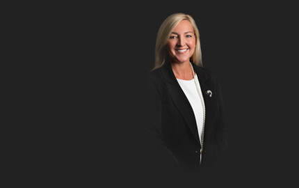 Lisa C. Keenan is smiling, wearing a black jacket, and a white shirt.