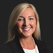 Lisa C. Keenan is smiling, wearing a black jacket, and a white shirt. Close up on face.