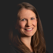 Molly E. G. Ferraioli is smiling and wearing a black dress. Close up on face.