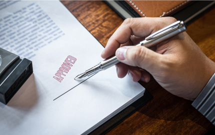 Close up hands of businessman signing and stamp on paper document