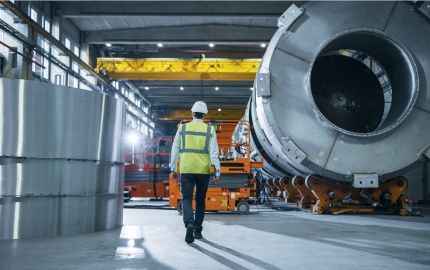 Shot of Heavy Industry Engineers Walking Through Manufacturing Factory