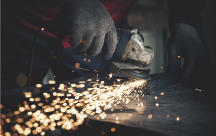 Worker grinding metal close up shot
