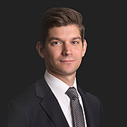 Brian G. Filler is wearing a black suit, white shirt, and black tie with white dots. Close up on face.