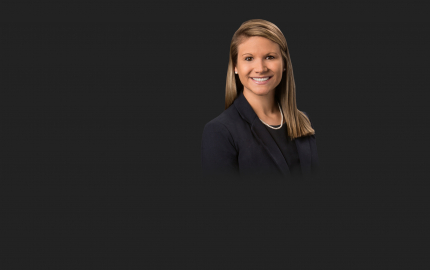 Elisabeth Koloup Hall is smiling, wearing a black jacket, and black shirt.
