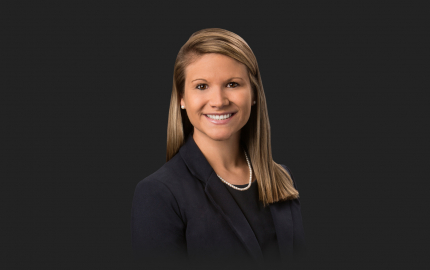 Elisabeth Koloup Hall is smiling, wearing a black jacket, and black shirt.