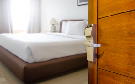 Empty hotel room with bed and door
