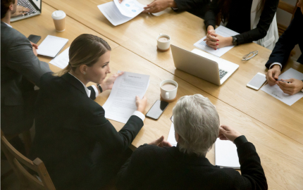 Business people discussing deal details at group meeting