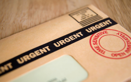 Close-up of letter with urgent stamp