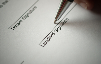Person preparing to sign a lease agreement in the Landlord Signature section.