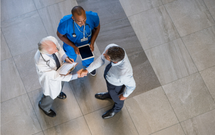 A medical professional holding a tablet, a medical professional holding a clipboard shaking hands with a professionally dressed person.
