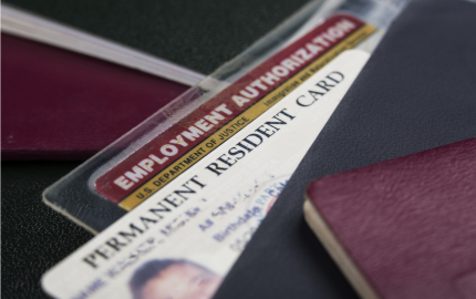 Close up view of top of a Permanent Resident Card and Employment Authorization cards.