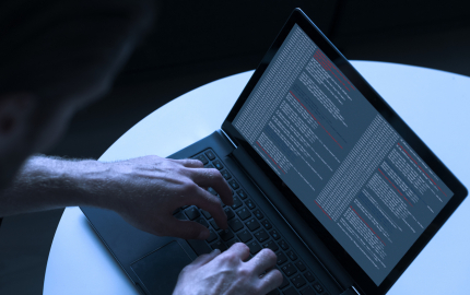 Hacker uses laptop to hack computer network and create cyber attacks