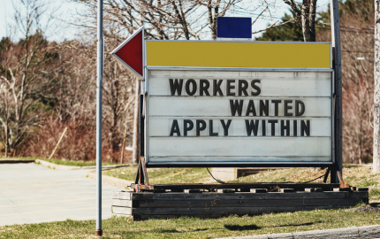 Outdoor sign stating Workers Wanted Apply Within.