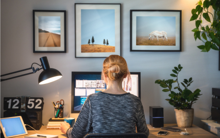 Person sitting in front of a computer in a home office.