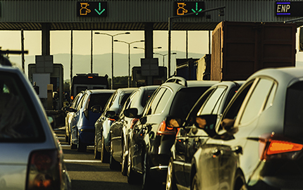 Cars waiting in line to pass through a toll booth.