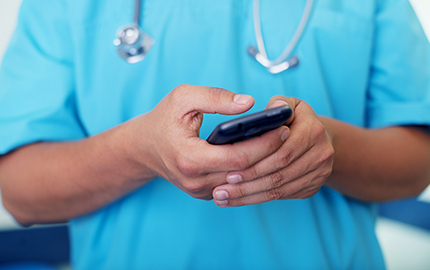 Medical professional holding a cellphone.