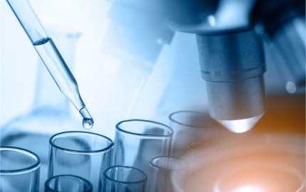 Dropper dropping liquid in a test tube and a close up of a microscopes lens.