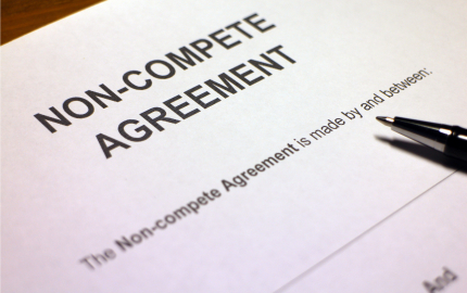 Front page of a blank Non-Compete Agreement with a pen lying on top.